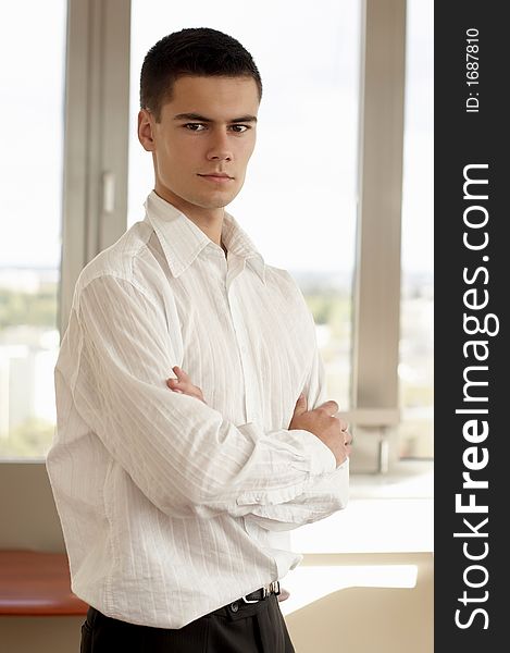 Young successful businessman in white shirt, in modern office