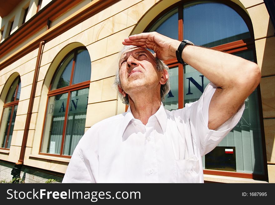 Grey-haired, old man looking at the sky on a summer day