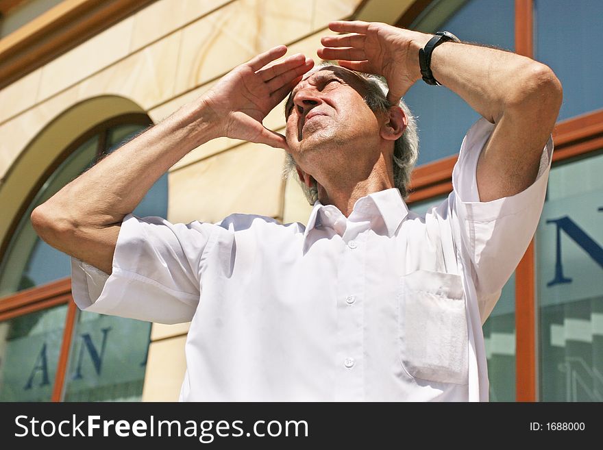 Grey-haired, old man looking at the sky on a summer day