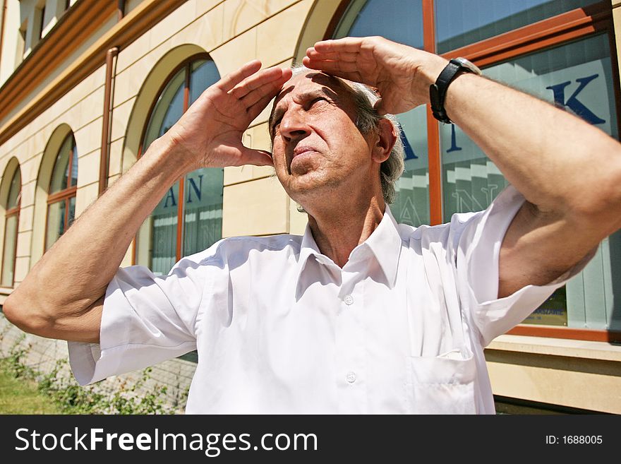 Grey-haired, old man looking at the sky on a summer day