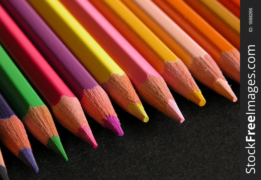 Color pencils isolated on black background.