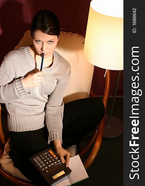 Girl, young woman with calculator and pen- on armchair