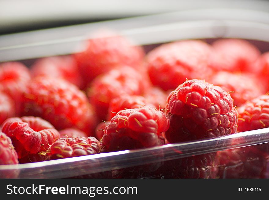 Deliciously fresh and tender raspberries macro in supermarket sales package