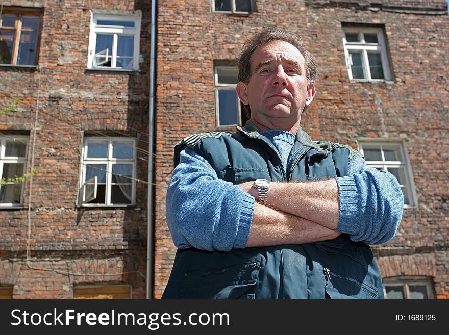 Man In Front Of Ruined House