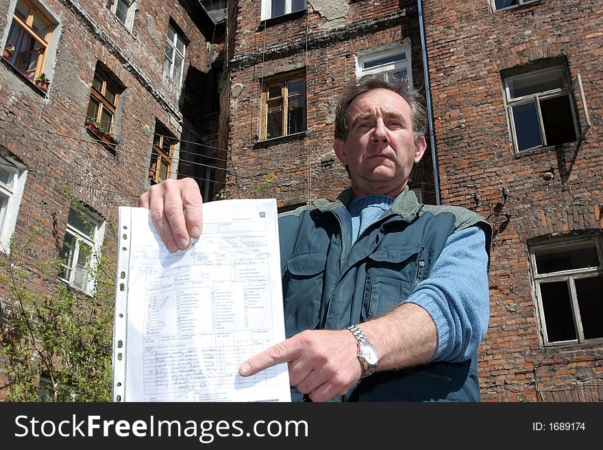 Man In Front Of Ruined House