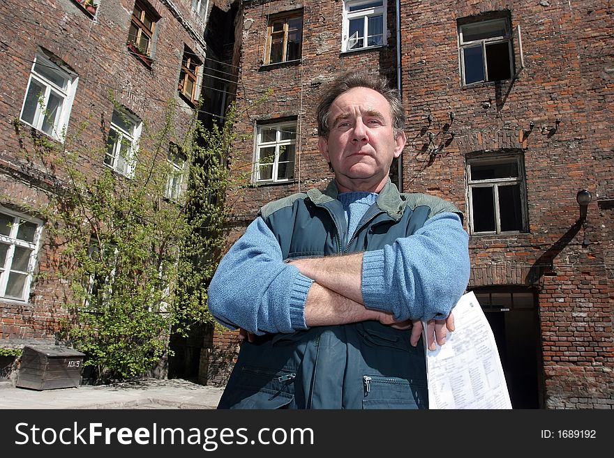 Man In Front Of Ruined House