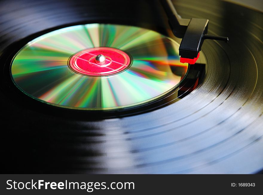 Abstract photo of Vinyl record compared against new technology-Compact Disc on a turn table.