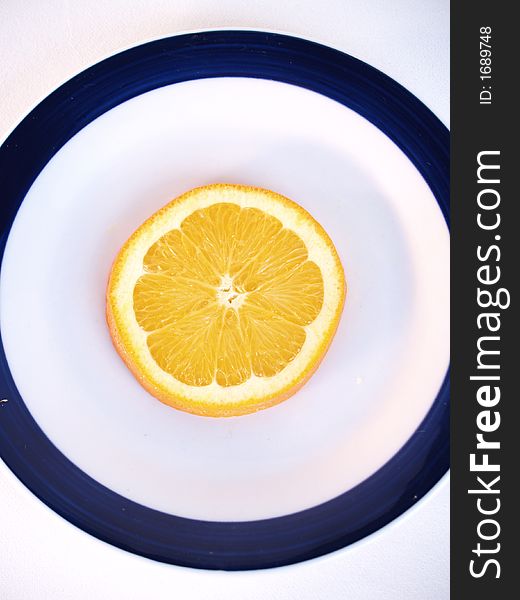 An orange sliced on a plate. An orange sliced on a plate