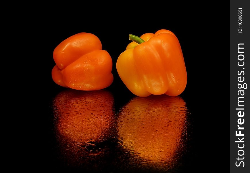 Single sweet pepper on a black background with water drops