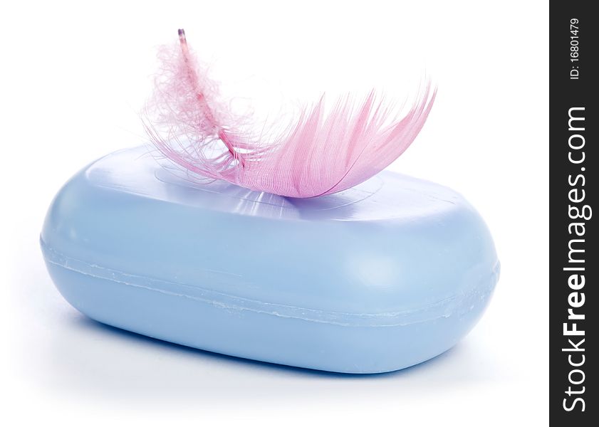 Blue new Soap Bar with pink Feather in soft-focus view. Isolated on white background.