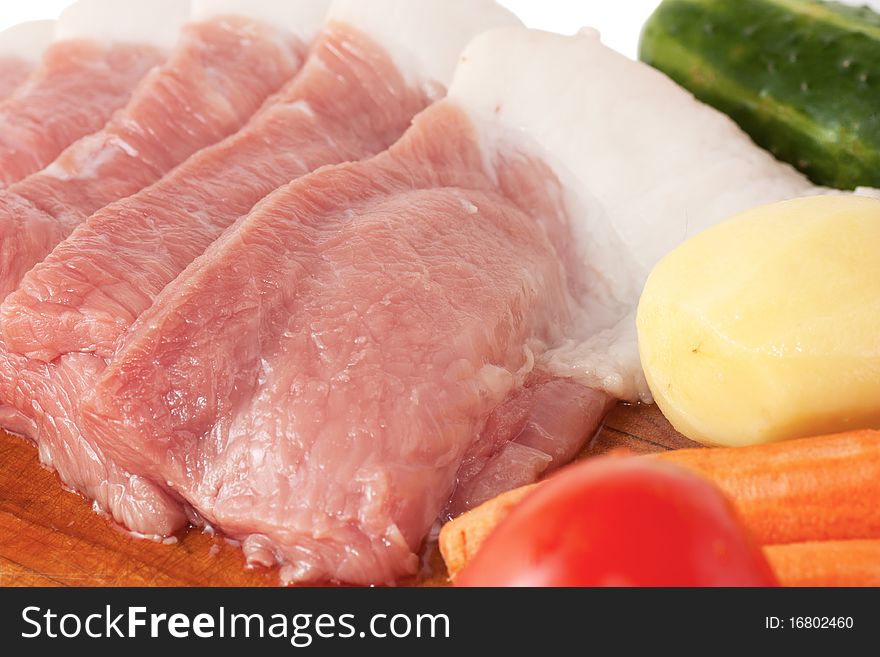 Unprepared meat and vegetables on a cutting board