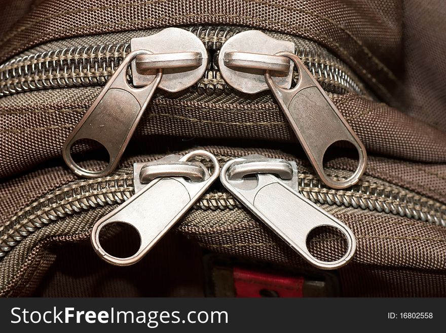 Closeup view of closed zippers on a bag.