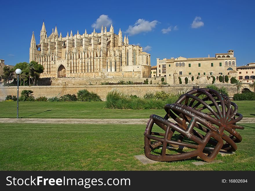 Modern abstract metallic sculpture in the foreground of the Palma de Mallorca gothic cathedral. Modern abstract metallic sculpture in the foreground of the Palma de Mallorca gothic cathedral