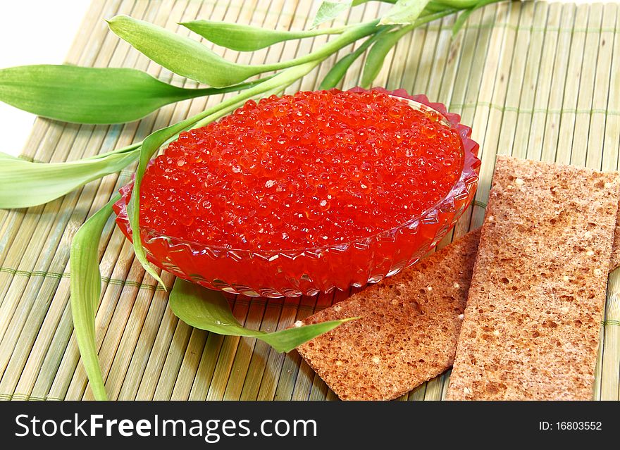 Glass flat dish filled with tasty red brilliant caviar. Glass flat dish filled with tasty red brilliant caviar