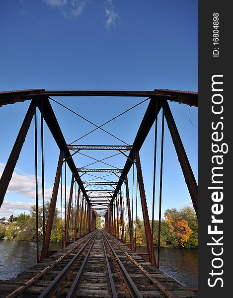 Rail length across the river on rusty steel bridge