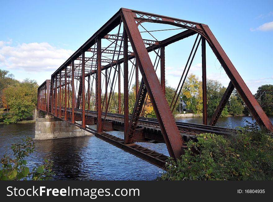 Rail length across the river on rusty steel bridge