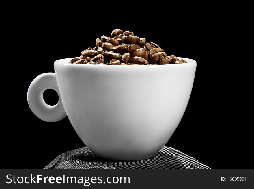 Cup with coffee grains, on a black background