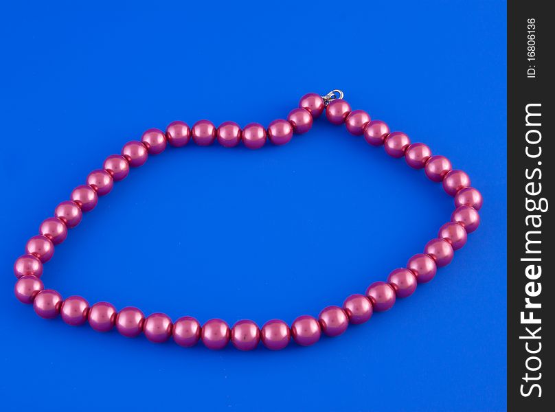 Red isolated beads over blue background. Image. Red isolated beads over blue background. Image.