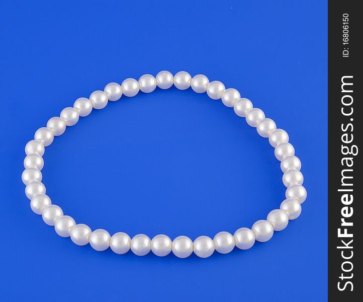White isolated beads over blue background. Image. White isolated beads over blue background. Image.