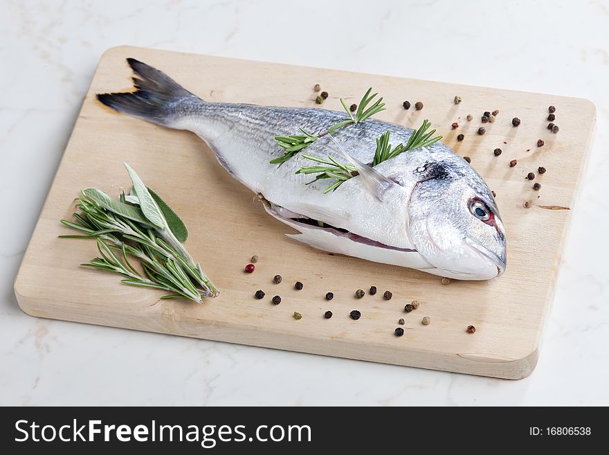Still life of raw bream with herbs