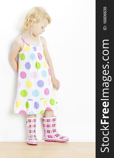 Little girl wearing dress and rubber boots. Little girl wearing dress and rubber boots