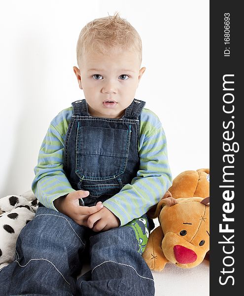 Sitting toddler boy with toys