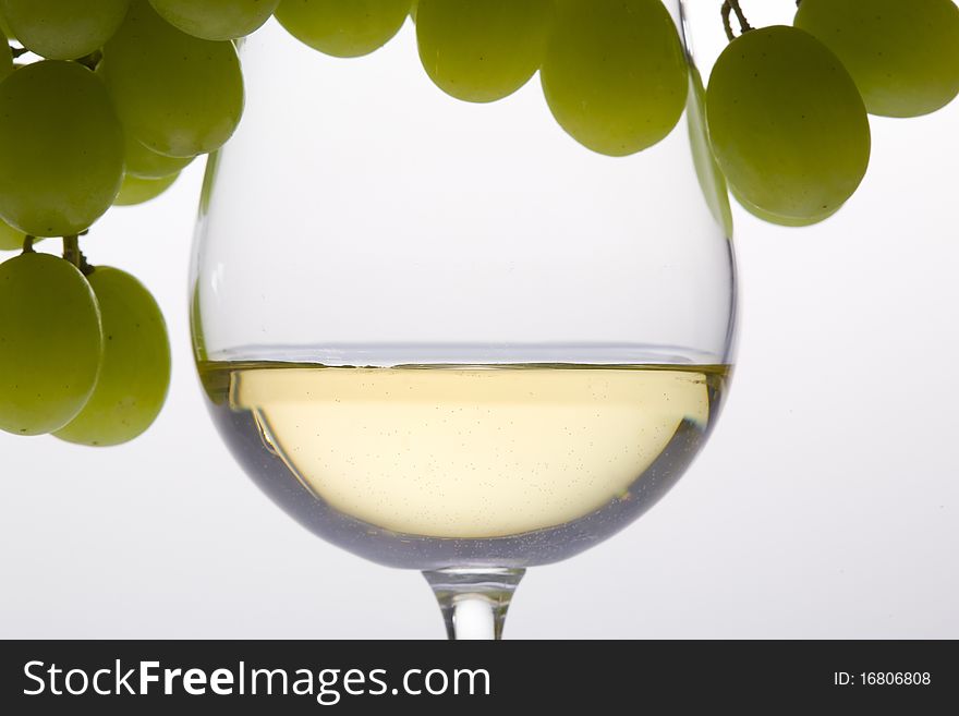Wineglass with white wine and grape