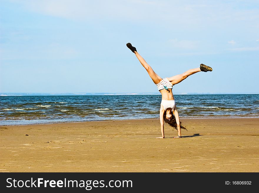 Young woman making exercise on the beach. Young woman making exercise on the beach.