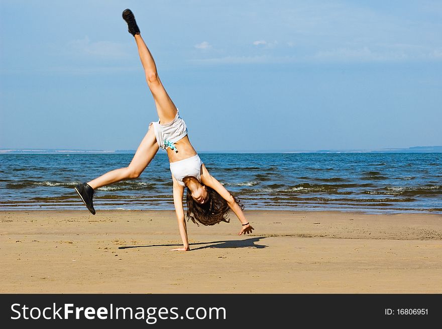 Young woman making exercise on the beach. Young woman making exercise on the beach.