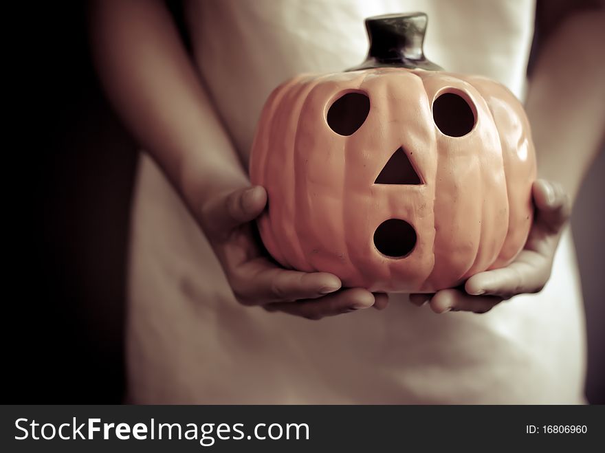 A child holds the pumpkin