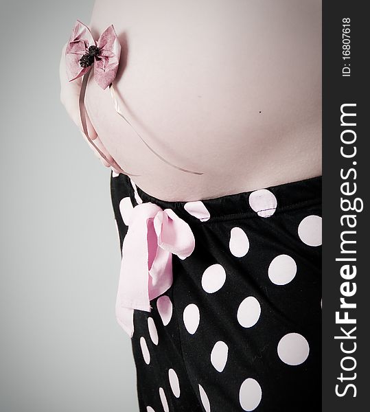 A pregnant beautiful woman. Grey Background. A pregnant beautiful woman. Grey Background