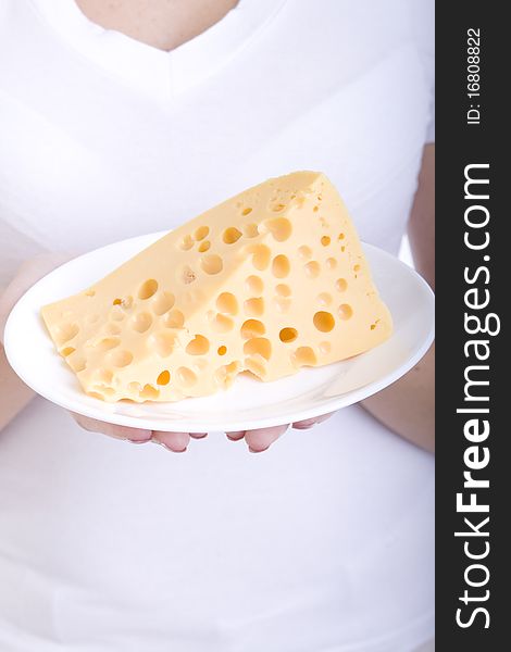 Slice of cheese on a plate, in the hands of a girl. Slice of cheese on a plate, in the hands of a girl