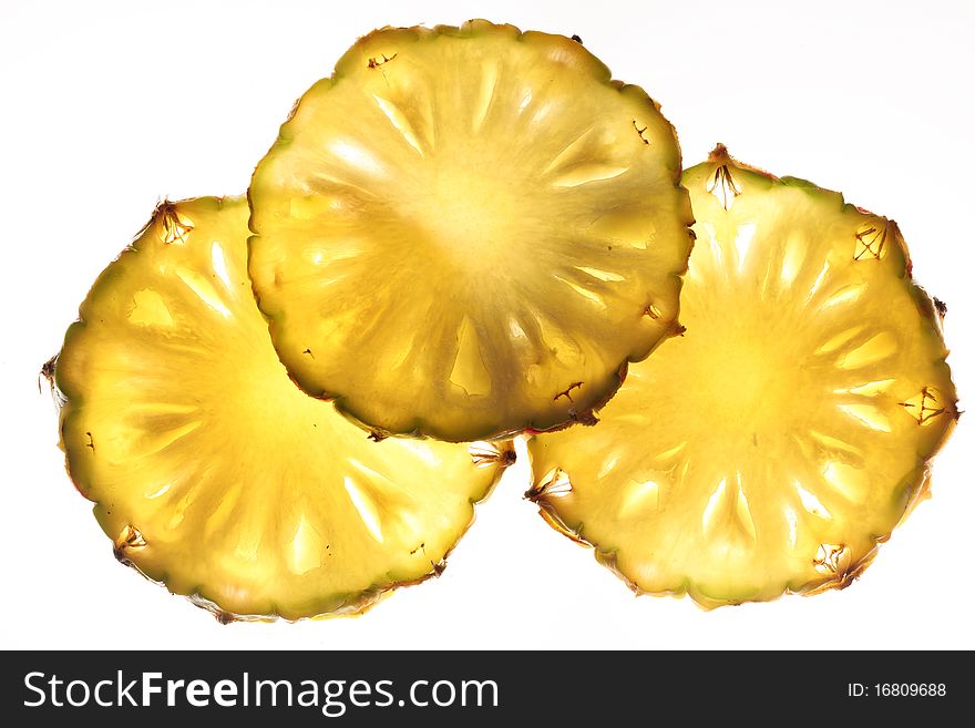 Cross cuts of pineapple back lighted. Isolated on a white. Cross cuts of pineapple back lighted. Isolated on a white.