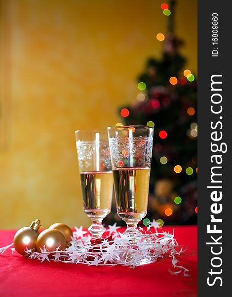 Two champane glasses against christmas three lights. Focus on champagne. Two champane glasses against christmas three lights. Focus on champagne.