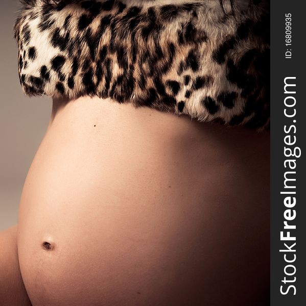 Young pregnant woman posing with a belly