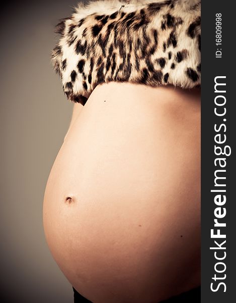 Young pregnant woman posing with a belly