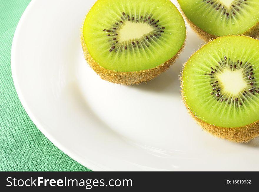 Kiwi fruit on white plate.