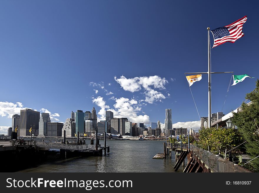 The New York City skyline w the american flag. The New York City skyline w the american flag
