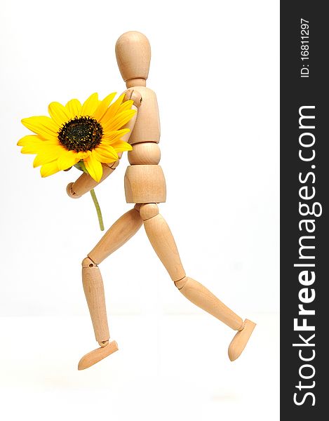 Wood figure with sunflower in arms over white background