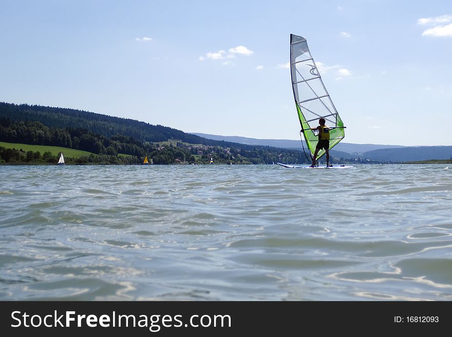 Lake St-Point in France, in summer, with people sailing on it.