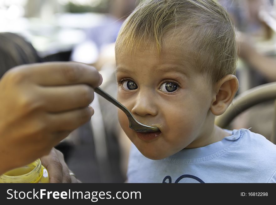 Beautiful Baby Boy Is Being Feed With A Spoon
