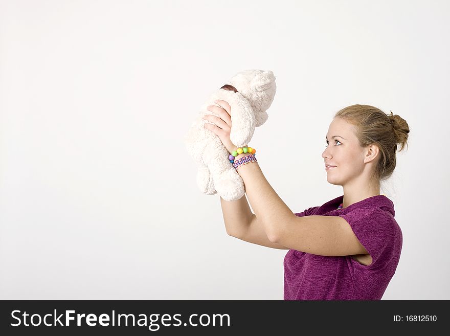 Smiling girl with a toy bear studio shot