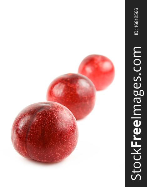 Three red plums isolated on white