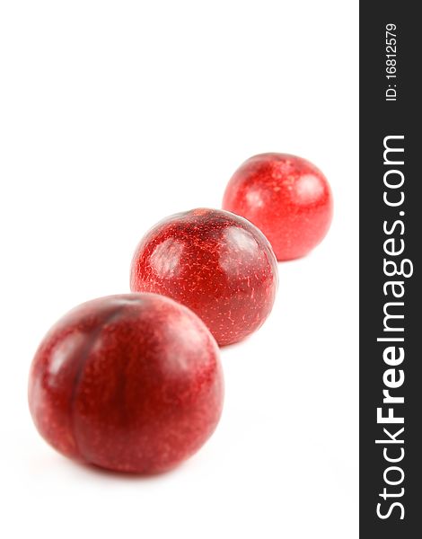 Three red plums isolated on white