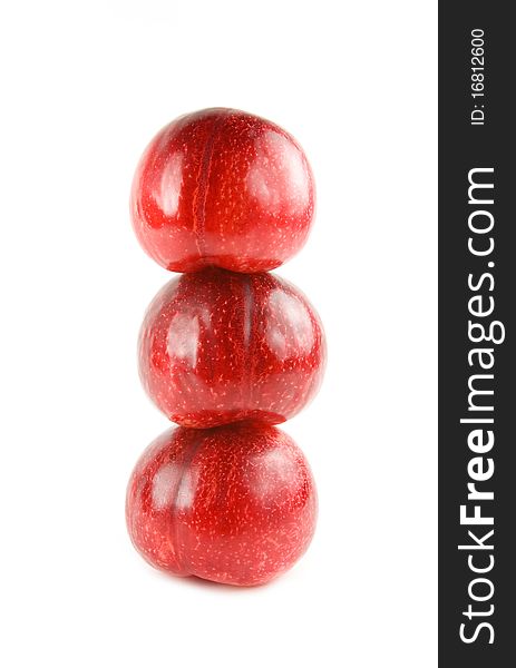 Three red plums isolated on white