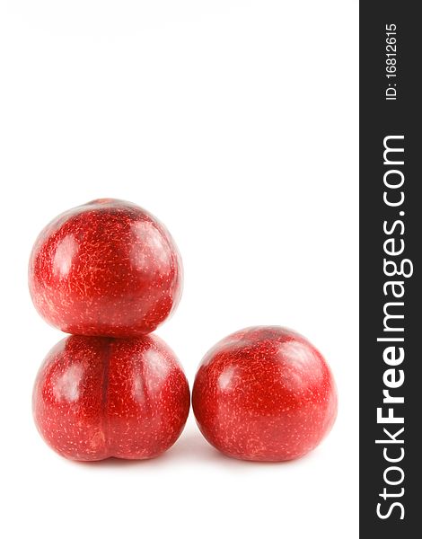 Three red plums isolated on white