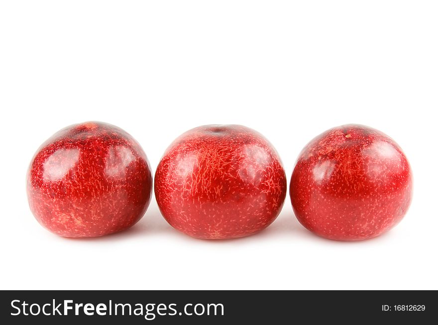 Three red plums isolated on white