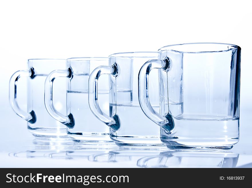 Four blue cups filled with water unevenly. Four blue cups filled with water unevenly