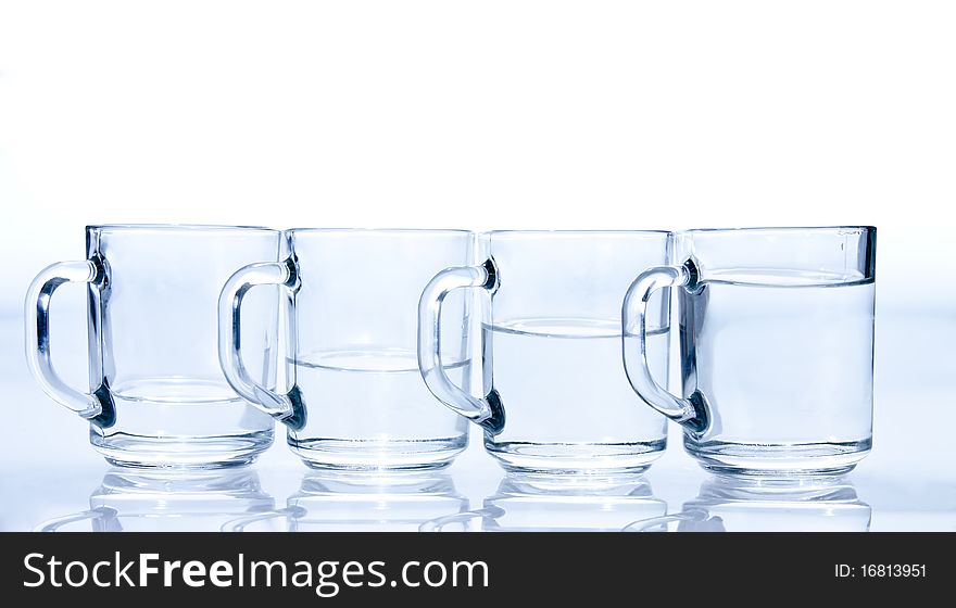 Four blue cups filled with water unevenly. Four blue cups filled with water unevenly