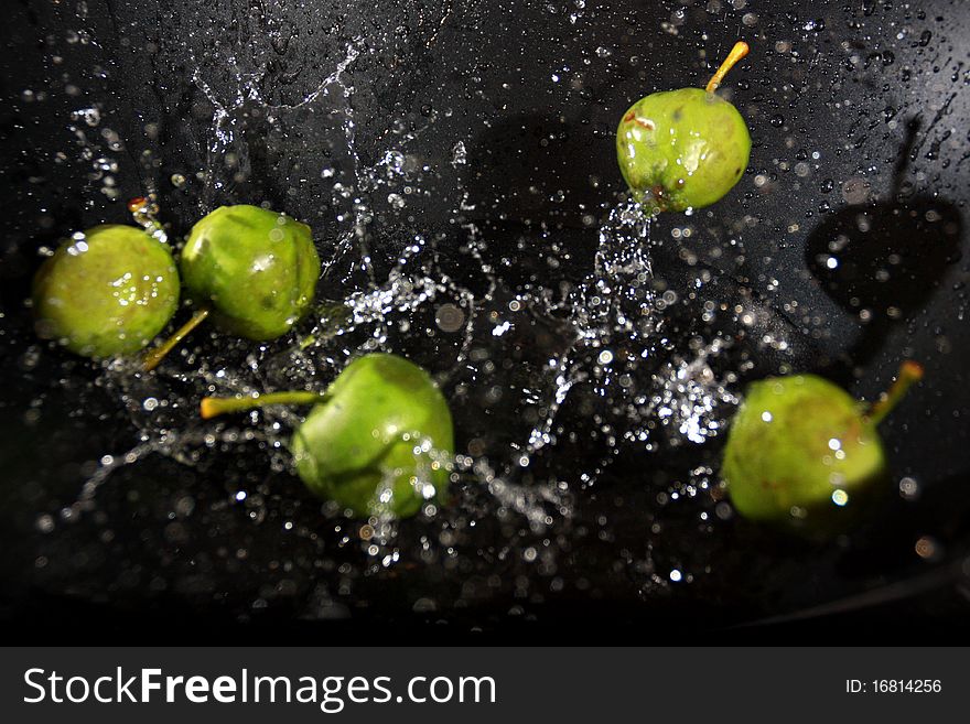 Small apples being dropped in water. Small apples being dropped in water